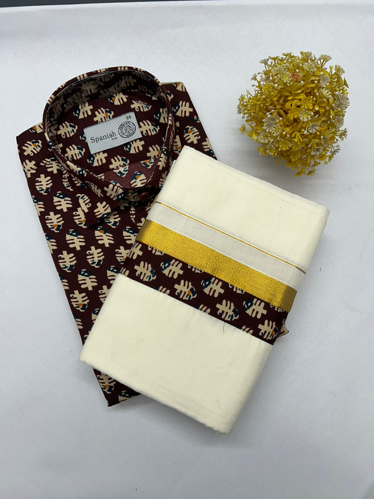 Two folded fabrics, one brown with a pattern and one white with a yellow stripe, on a white background.